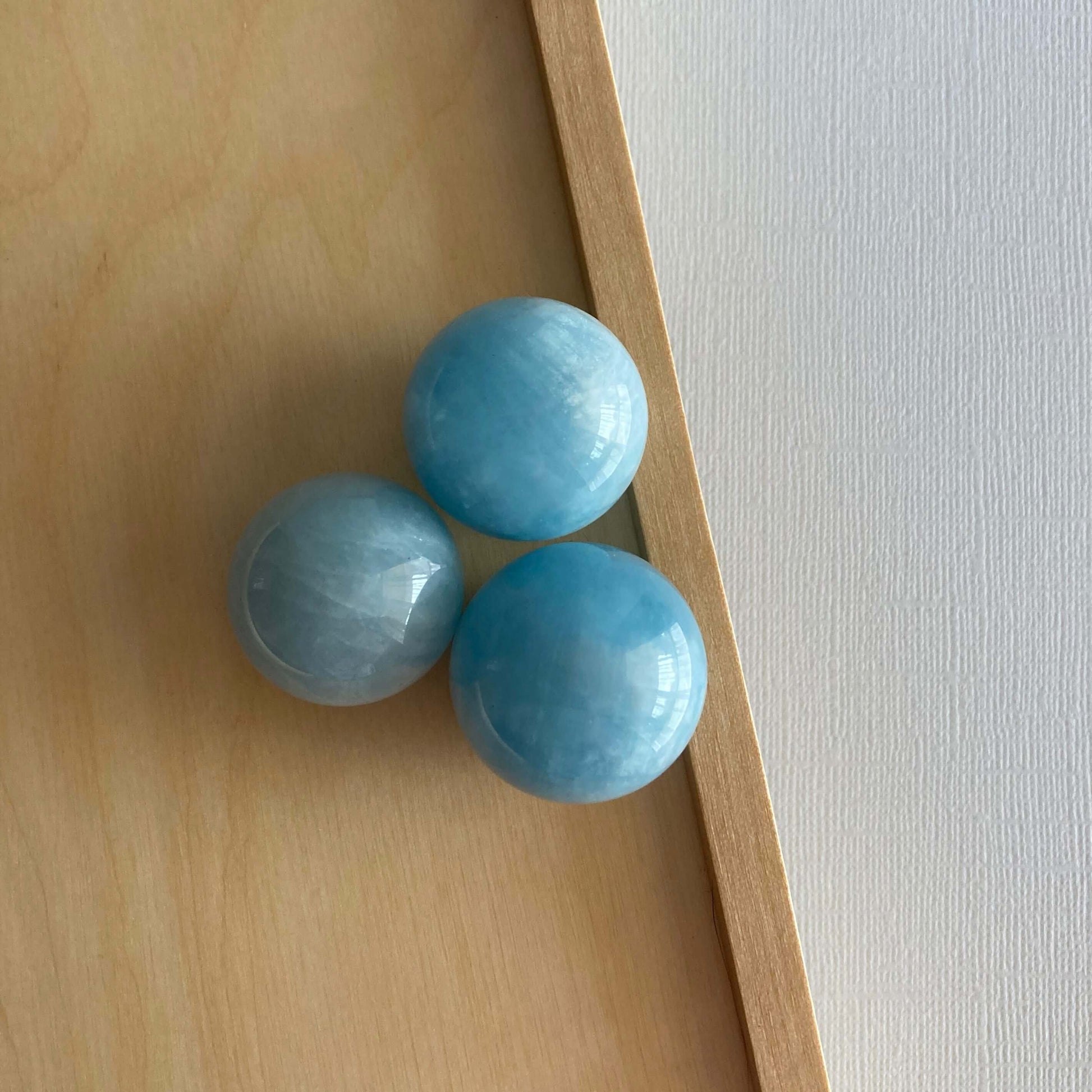 3 Aquamarine spheres on a wooden box