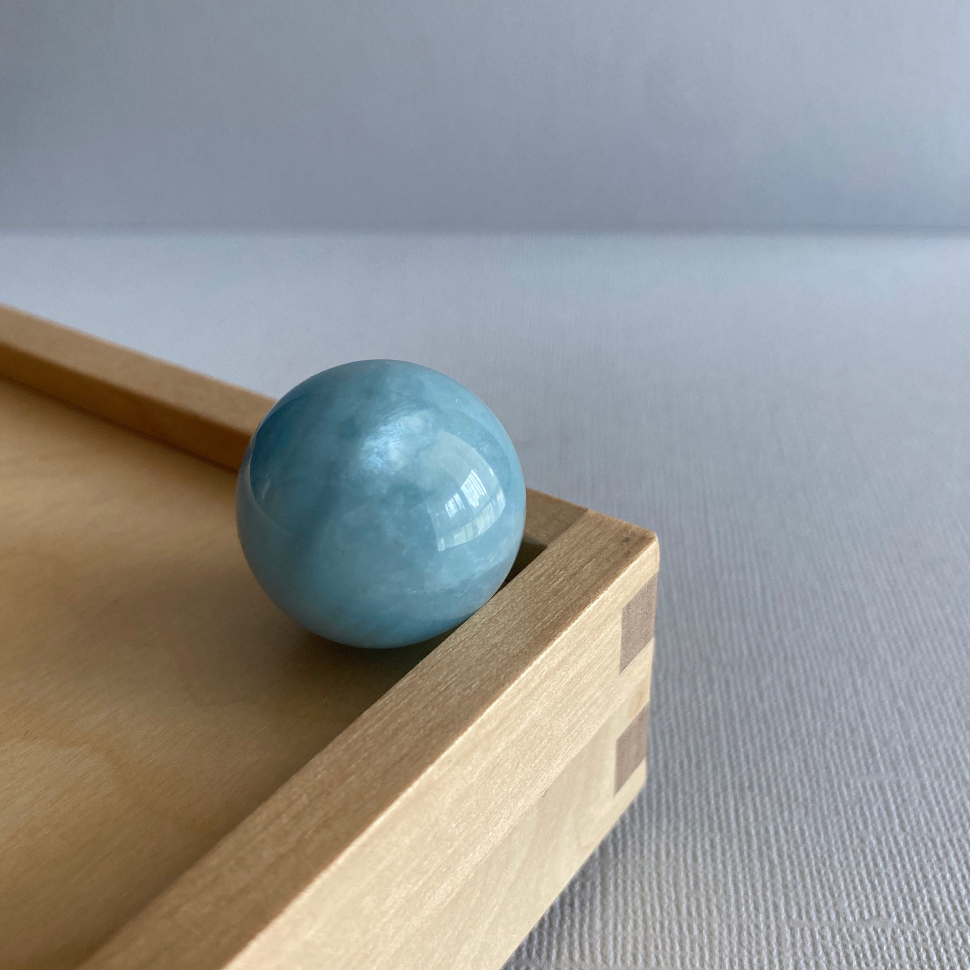 Aquamarine sphere on a wooden box