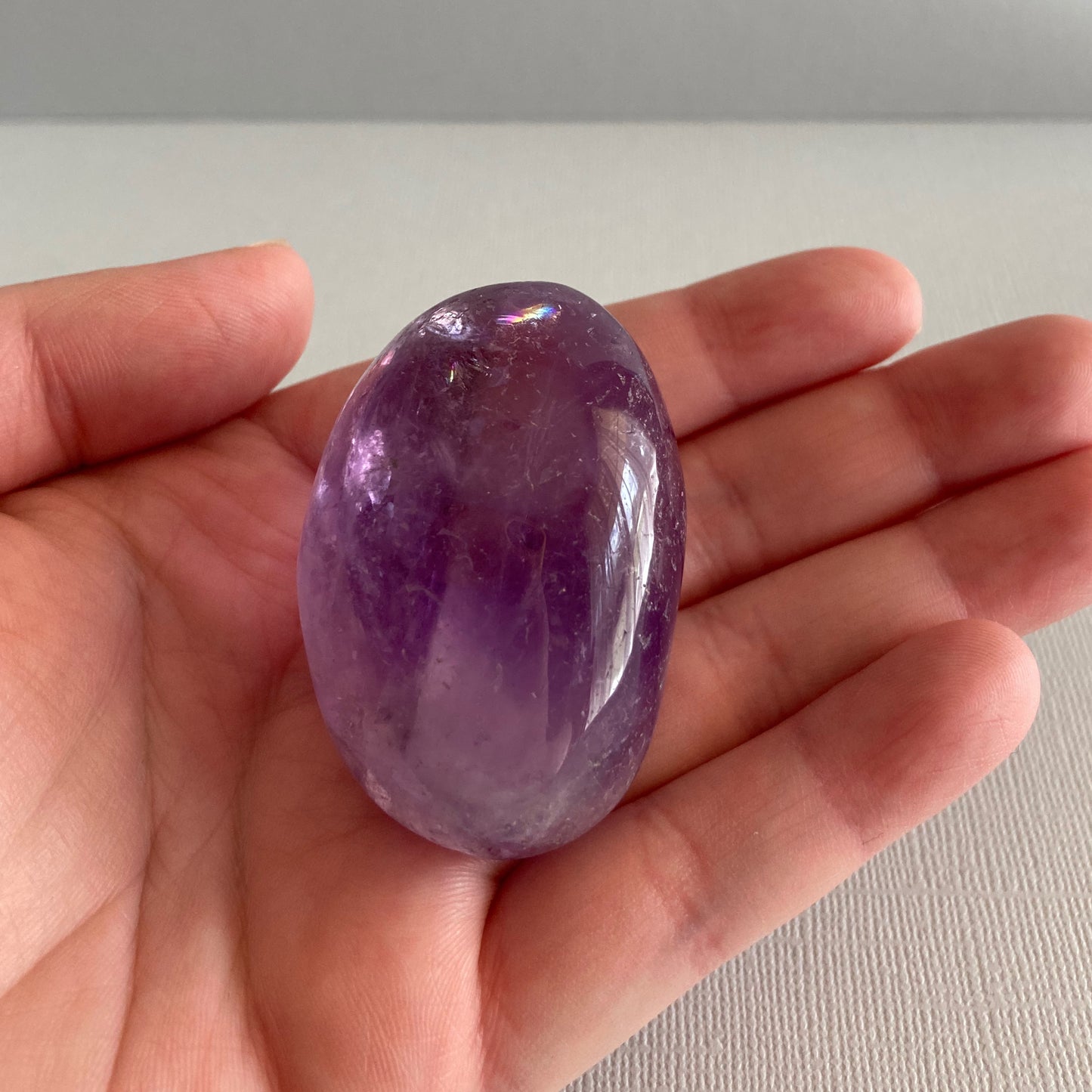 High quality Amethyst palmstone shown in a hand