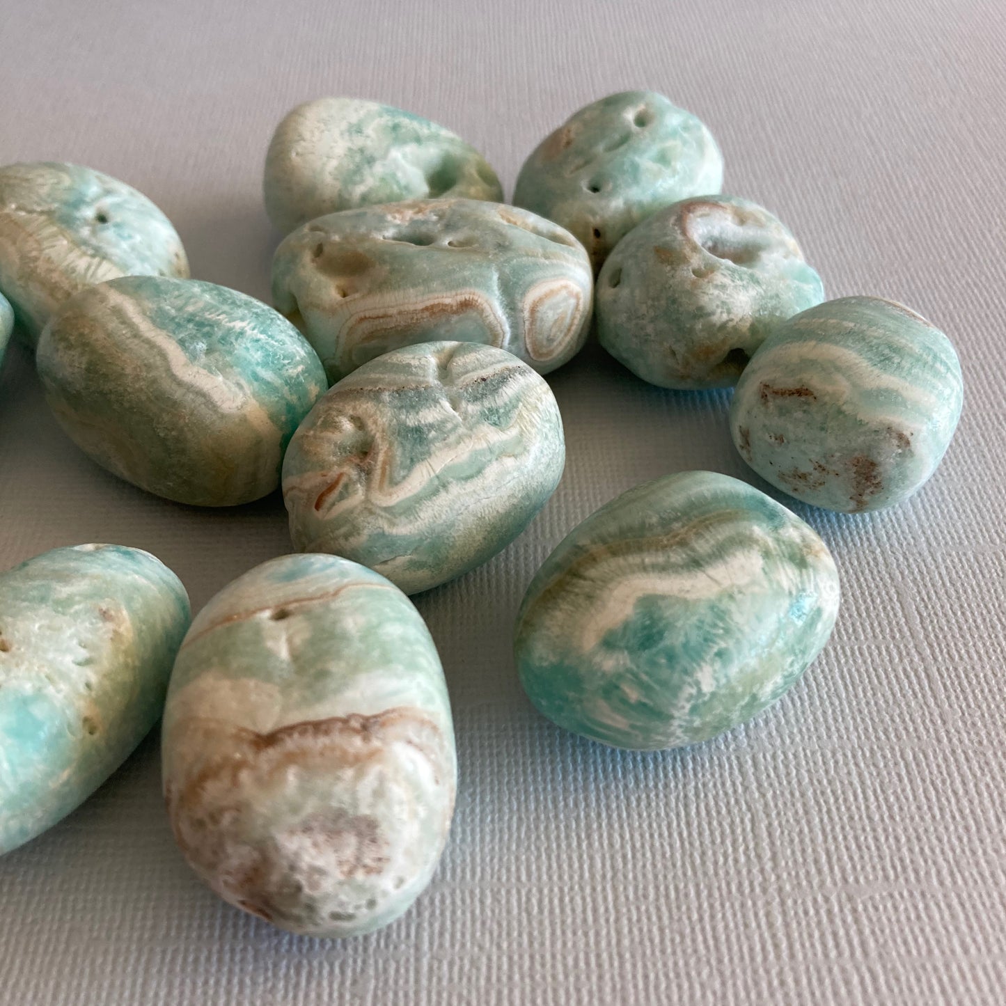 A closeup of a group of Blue Aragonite tumbles